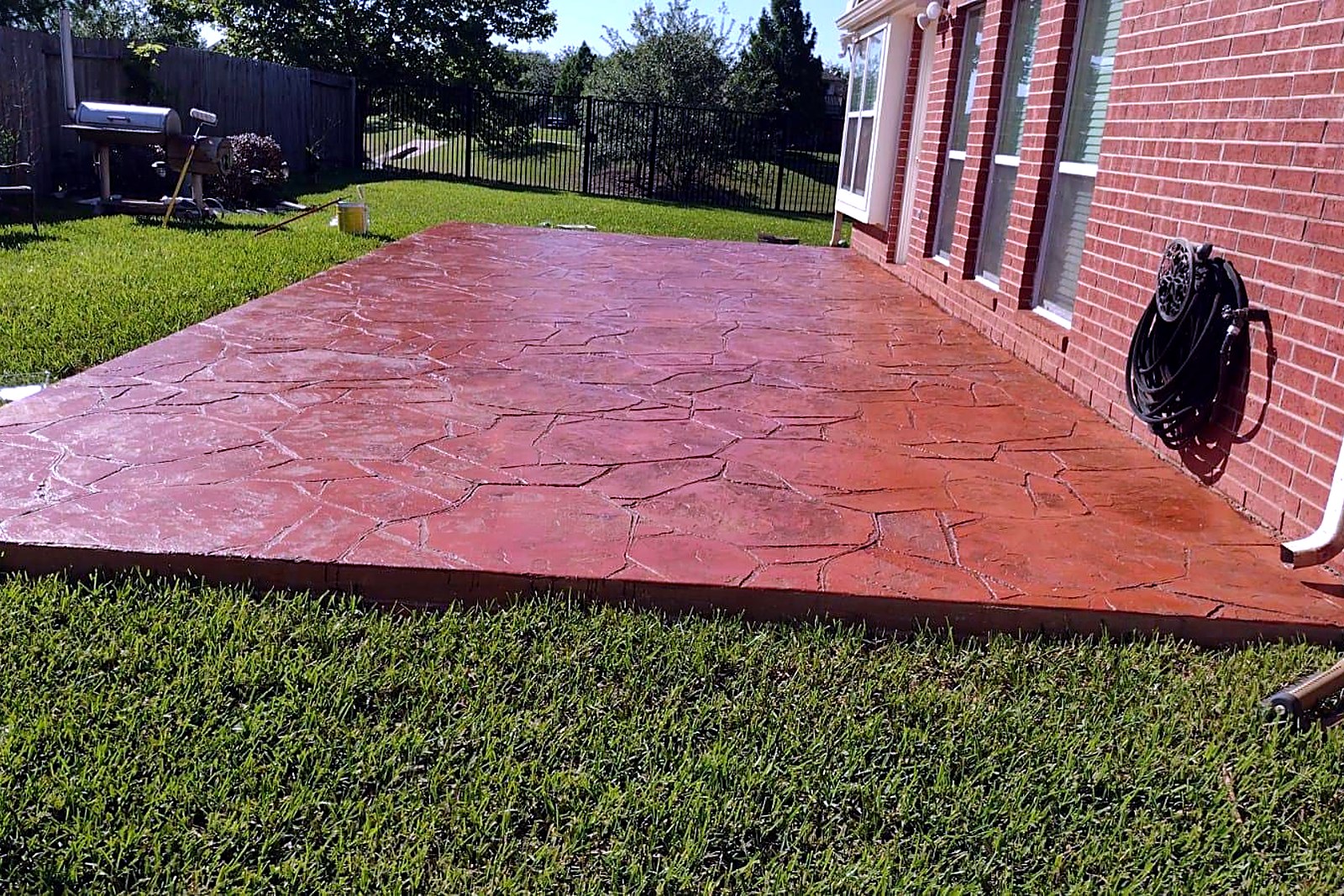 Large stamped concrete patio in a terracotta tone with a flagstone pattern