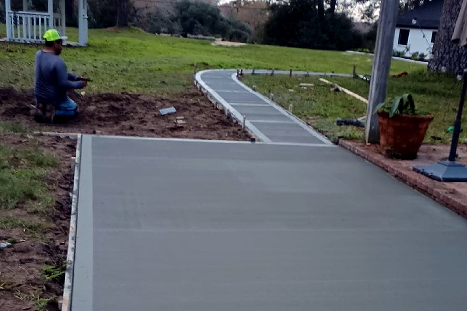 Curved concrete walkway with a light broom finish while the surface is still fresh