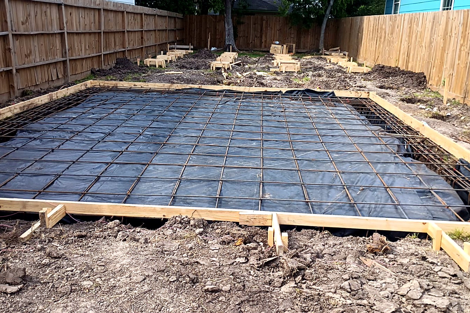 Square shop pad forms with a rebar grid prepared for a concrete pour
